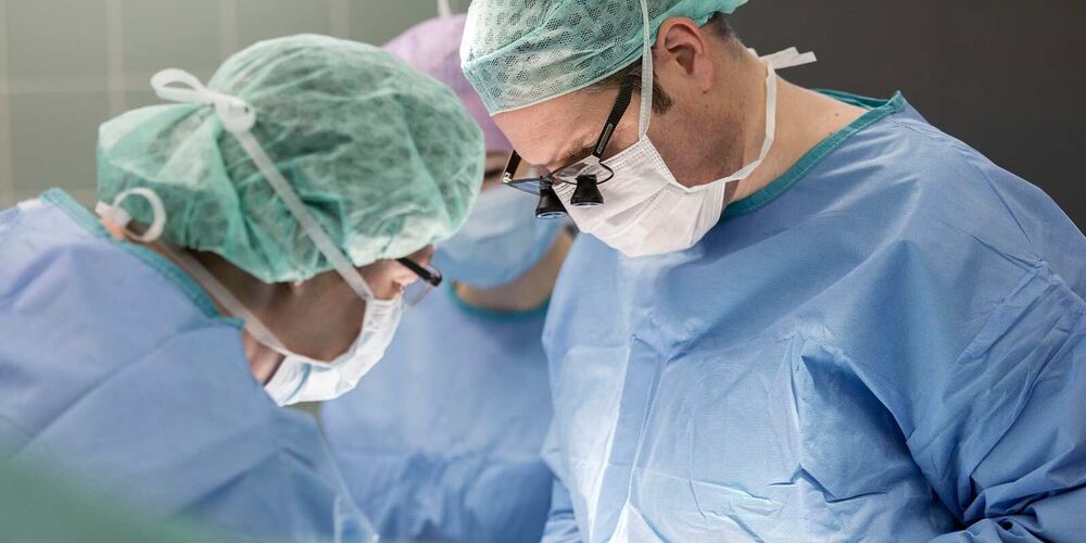Zwei Ärzte an einem Operationstisch in einem Operationssaal 