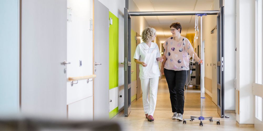 Eine Mitarbeiterin der Gynäkologie betreut eine Patientin auf der onkologischen Station.