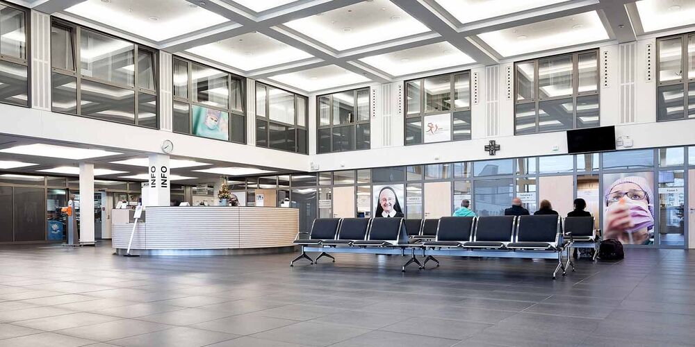 Eingangsbereich des Johanna-Etienne Krankenhauses. In diesem befinden sich Sitzmöglichkeiten und ein Infostand. 