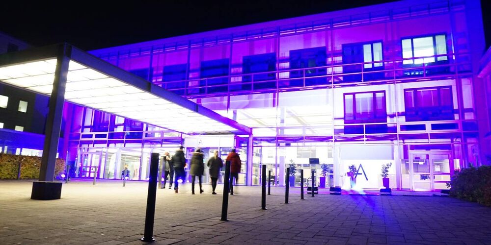 Außenansicht des Johanna Etiennen Krankenhauses, welches lila angeleuchtet wird.