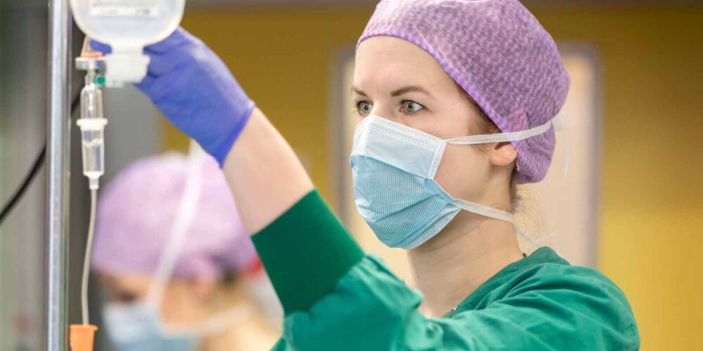 Eine Frau in Operationskleidung, welche die Anästhesie überprüft.